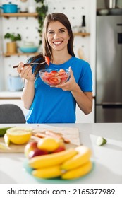 Happy Woman Holding Bowl Of Salad And Looking At Camera