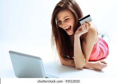 A Happy Woman Holding A Credit Card And Shopping From The Internet