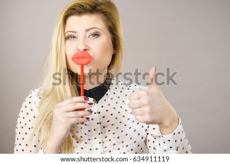 Happy woman holding fake lips on stick having fun. Photo and carnival funny accessories concept.