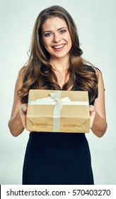 Happy Woman Holding Gift Box. Isolated Portrait Of Girl Wearing Black Dress.