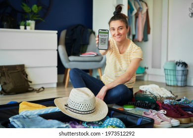 Happy woman holding mobile phone with digital vaccination card - Powered by Shutterstock