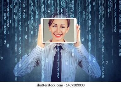 Happy woman holding tablet with her face displayed on a screen isolated on binary code background 