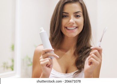 Happy Woman Holding Toothbrush And Toothpaste