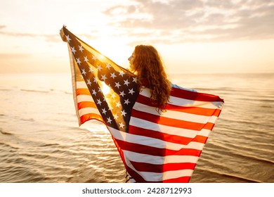 Happy woman holding United States of America flag and running  on the beach at sunset. Patriotic holiday. USA celebrate 4th of July. Independence Day concept - Powered by Shutterstock