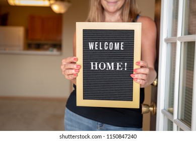 Happy Woman Holding Welcome Home Sign