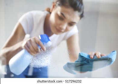 Happy Woman House Wife Cleaning Glass Table In Home