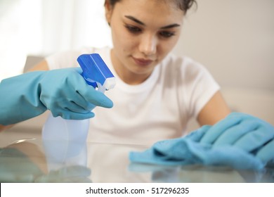 Happy Woman House Wife Cleaning Glass Table In Home