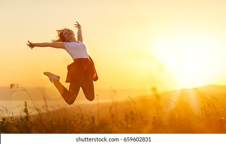 Happy Woman   Jump,  Rejoices, Laughs  On Sunset In Nature 