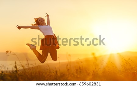 Happy woman   jump,  rejoices, laughs  on sunset in nature 