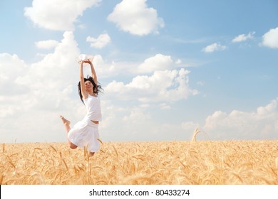 Happy Woman Jumping In Golden Wheat