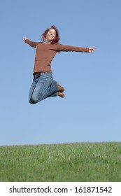Happy woman jumping on grass field
