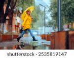 
Happy Woman Jumping Over Puddles Enjoying Rain. Cheerful lady running in the city in a rainy day
