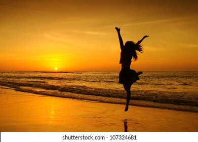 Happy Woman Jumping in Sea Sunset - Powered by Shutterstock