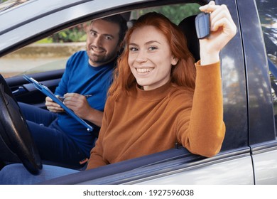 Happy woman learning to drive with instructor