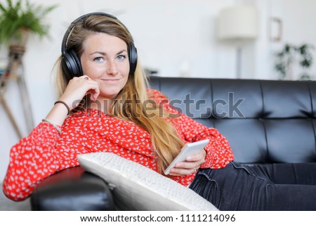 Happy woman listening to music wearing headphones