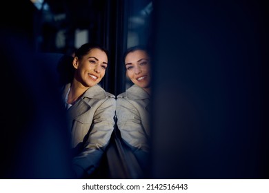 Happy Woman Looking Through Window While Enjoying Her Train Journey. The View Is Through Passengers Seats. Copy Space. 