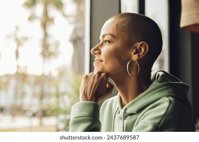 Happy woman looking through the window with relaxed and happy