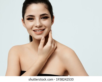 Happy Woman With Makeup On Face Touching Face With Hand