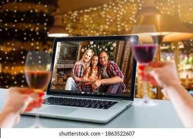 Happy Woman Making A Toast On Video Call Celebrating Christmas With Glass Of Wine Online During Coronavirus Outbreak - Focus On Wine Glass