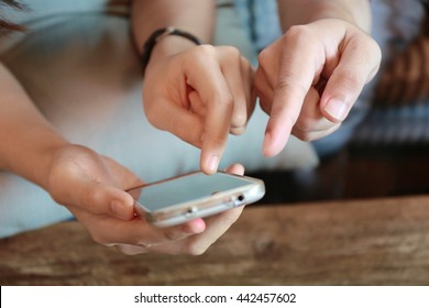 Happy woman and man hand point finger on phone on table,relationship ,the internet of things.Couple people touching on mobile phone while working and discussion, relaxing lifestyle, together