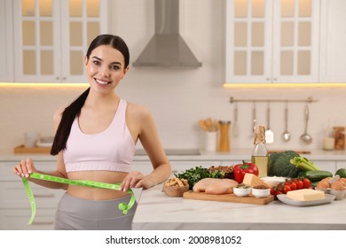 Happy Woman Measuring Waist With Tape In Kitchen. Keto Diet