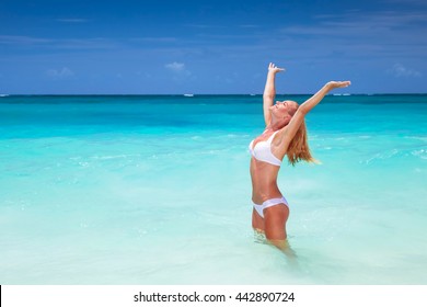 Happy Woman On The Beach With Raised Up Hands, Enjoying Bright Sunny Day, Travel To Islands