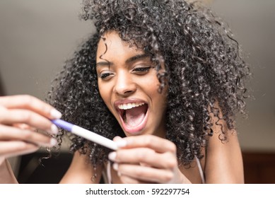 Happy Woman On Bed With A Pregnancy Test 