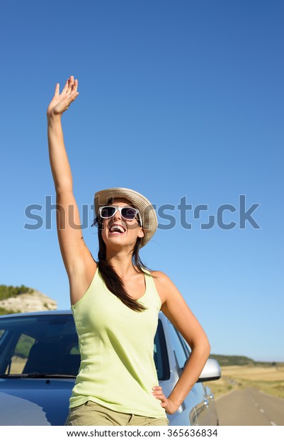 Happy woman on car roadtrip
waving and having fun. Tierra de Campos, Castilla y Leon,
Spain.