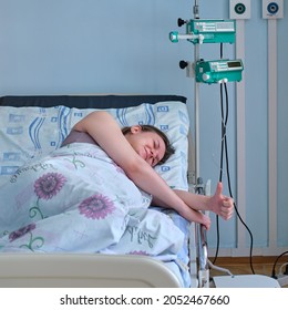 Happy woman on clinic bed with anesthesia at the time of labor pains. A pregnant woman gives birth in a hospital with a drip and a CTG machine