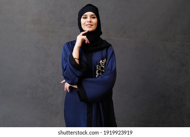 Happy woman on Hijab Abaya looking at the front camera while smiling, on isolated copy space background. Arab expressing positivity