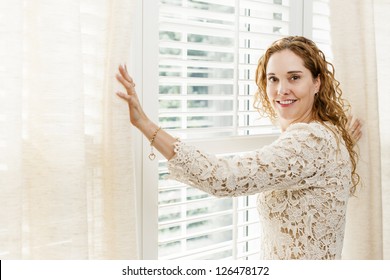 Happy Woman Opening Curtains On Big Sunny Window With Shutters