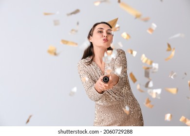 Happy Woman With Party Popper On Light Background