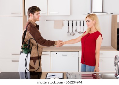 Happy Woman And Pest Control Exterminator Worker Shaking Hands After Termite Pesticide Spraying At Home