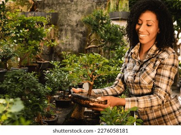 happy woman picking bonsai plant at plant nursery - Powered by Shutterstock