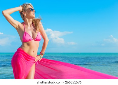 Happy woman in pink bikini covered with piece of fabric