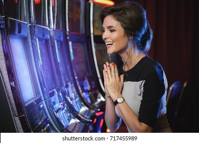 Happy Woman Playing Slot Machines In The Casino