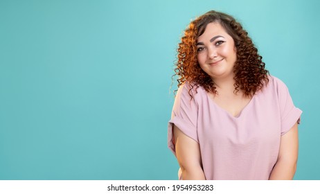 Happy Woman. Plus Size Beauty. Body Positive. Model Shooting. Conceptual Portrait. Smiling Fatty Lady With Curly Hairs Casual Style Looking At Camera Isolated Blue Copy Space.