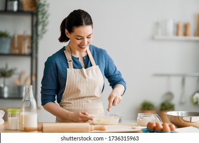 Happy Woman Is Preparing Bakery. Girl Is Cooking Cookies In The Kitchen. Homemade Food.