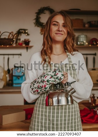 happy woman preparing christmas new year dinner and holding teapot