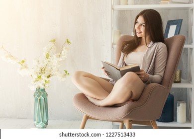 Happy woman reading book by the window on spring morning - Powered by Shutterstock