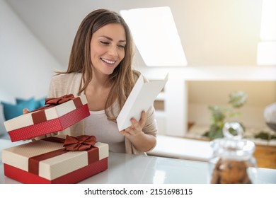 Happy Woman Receive A Gift Box. She Is Smiling While Reading A Greeting Card. 