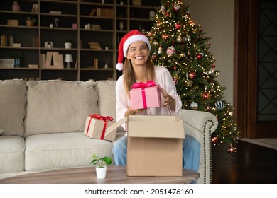 Happy Woman Receiving Delivery Box With Christmas Gifts, Unpacking Parcel With New Year Presents, Holding Festive Wraps, Unboxing Received Package, Smiling At Camera, Smiling. Xmas Portrait