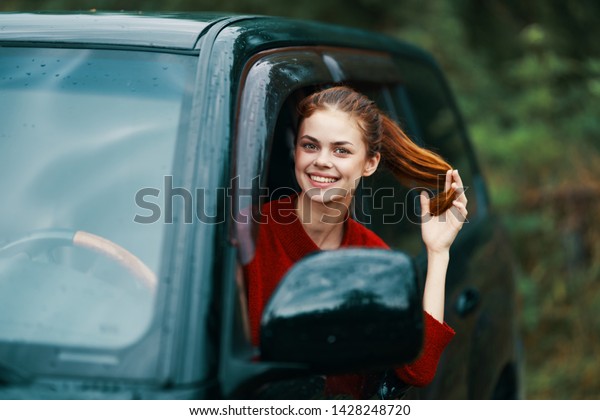Happy\
woman red hair black car driver rear view\
window