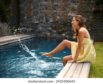 Happy, woman and relax with splash in pool on summer, holiday or vacation in California. Girl, smile and sitting outdoor on deck in backyard or garden with feet in water with casual style or fashion - Powered by Shutterstock