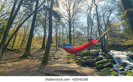 Happy woman relaxes, lying in a hammock in forest, adventure outdoor activity                                 - Powered by Shutterstock