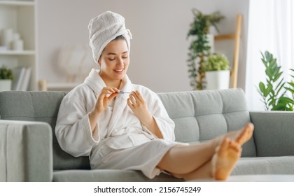 Happy woman is relaxing and caring for her nails after a bath. - Powered by Shutterstock