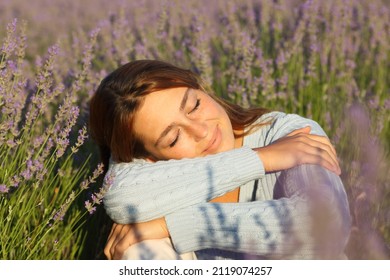 Happy woman relaxing with closed eyes sitting in lavender field