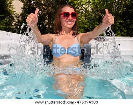 Happy woman relaxing in hot tub.