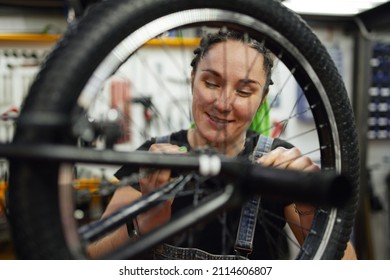 Happy Woman Repairing Bike In Garage