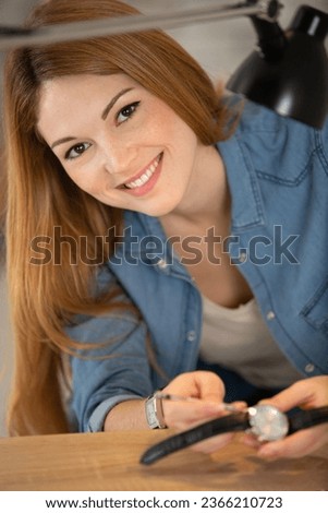 happy woman repairing vintage clocks